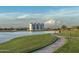 Picturesque view of a serene community lake with walking path, lush green spaces, and a distant mountain backdrop at 3830 E Appaloosa Rd, Gilbert, AZ 85296