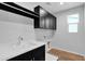 Well-lit laundry room with a sink, black cabinetry, and wood-look flooring at 3830 E Appaloosa Rd, Gilbert, AZ 85296