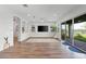 Bright living room featuring wood floors, white walls, sliding glass doors, and minimalist decor at 3830 E Appaloosa Rd, Gilbert, AZ 85296