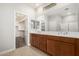 Bathroom featuring double sinks, tile floors, and a walk-in closet at 4695 N 204Th Ave, Buckeye, AZ 85396