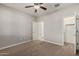 Comfortable bedroom featuring neutral walls, carpet, ceiling fan, and easy access to the en-suite bathroom at 4695 N 204Th Ave, Buckeye, AZ 85396