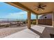 Relaxing covered patio with an outdoor fan, overlooking the landscaped backyard and fencing at 4695 N 204Th Ave, Buckeye, AZ 85396