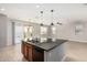Kitchen island with granite counters, tile floors, and a view of the dining and living areas at 4695 N 204Th Ave, Buckeye, AZ 85396