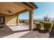 Covered patio with ceiling fan overlooks landscaped backyard with brick walkway and view fencing at 4695 N 204Th Ave, Buckeye, AZ 85396