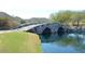 Picturesque stone bridge over a pond, surrounded by lush greenery and scenic views at 4695 N 204Th Ave, Buckeye, AZ 85396