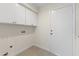 Neat laundry room with white cabinets and a utility sink, plus washer/dryer hookups at 5202 E Marconi Ave, Scottsdale, AZ 85254