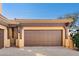 This expansive garage features a stylish carriage-style door and accent lighting under a clear blue sky at 5370 S Desert Dawn Dr # 39, Gold Canyon, AZ 85118
