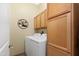 Bright laundry room with full-size washer and dryer, wood cabinets, and decorative wall art at 5370 S Desert Dawn Dr # 39, Gold Canyon, AZ 85118