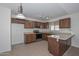 Well-lit kitchen with wooden cabinets, stainless steel appliances, and breakfast bar at 7044 W Sierra St, Peoria, AZ 85345