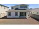 Backyard view of house featuring covered patio, dark windows, and gravel at 7449 W Buckhorn Trl, Peoria, AZ 85383
