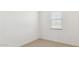 A cozy bedroom with neutral carpet, fresh white paint, and a window with blinds at 7449 W Buckhorn Trl, Peoria, AZ 85383