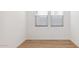 An airy bedroom with wood-look flooring and natural light from the two windows with blinds at 7449 W Buckhorn Trl, Peoria, AZ 85383