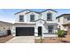 Charming white two-story home featuring a black two car garage and well-manicured landscaping at 7449 W Buckhorn Trl, Peoria, AZ 85383