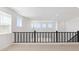 Hallway features a neutral carpet, black metal railing, and natural light from the ceiling at 7449 W Buckhorn Trl, Peoria, AZ 85383