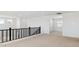 Hallway features a neutral carpet, black metal railing, and natural light from several windows at 7449 W Buckhorn Trl, Peoria, AZ 85383