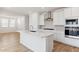 Modern kitchen with stainless steel vent hood, island sink, and open floorplan at 7449 W Buckhorn Trl, Peoria, AZ 85383