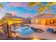 Backyard pool with desert landscaping and a lounge area with a table under an umbrella on a concrete patio at 835 E Virgo Pl, Chandler, AZ 85249