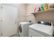 Functional laundry room equipped with a washer, dryer, and shelving for efficient organization at 835 E Virgo Pl, Chandler, AZ 85249