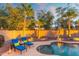 Inviting pool area illuminated at dusk, surrounded by palm trees and a stylish outdoor seating at 835 E Virgo Pl, Chandler, AZ 85249