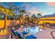 Inviting pool area illuminated at dusk, surrounded by palm trees and a stylish outdoor seating at 835 E Virgo Pl, Chandler, AZ 85249