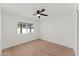 This bedroom has wood-look flooring, a ceiling fan, and a backyard view at 8419 N 51St Dr, Glendale, AZ 85302