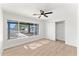 Bright bedroom features wood-look flooring, ceiling fan, and a large window with neighborhood views at 8419 N 51St Dr, Glendale, AZ 85302
