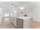 Open kitchen with an island, stainless steel dishwasher, and view into an adjacent living room with a fireplace at 8419 N 51St Dr, Glendale, AZ 85302