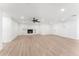 An open living room showcasing a ceiling fan and a cozy, painted brick fireplace at 8419 N 51St Dr, Glendale, AZ 85302