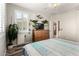 Well-lit bedroom featuring wood-look floors, ceiling fan, TV, and a collection of potted plants at 9144 W Surrey Dr, Peoria, AZ 85381