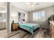 Bright bedroom features shuttered windows, ceiling fan, wood-look floors, and a cozy, colorful comforter at 9144 W Surrey Dr, Peoria, AZ 85381
