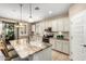 Open concept kitchen with stainless appliances, granite counters, stylish pendant lights and tile floors at 9144 W Surrey Dr, Peoria, AZ 85381