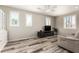 Bright living room with wood-look floors, shuttered windows, and a ceiling fan at 9144 W Surrey Dr, Peoria, AZ 85381