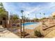 Fenced community pool boasts clear blue water, surrounding desert landscaping, and relaxing lounge area under palm trees at 9716 N 3Rd Dr, Phoenix, AZ 85021