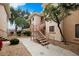 Inviting condo exterior featuring well-maintained landscaping and stairs leading to upper levels at 10030 W Indian School Rd # 203, Phoenix, AZ 85037