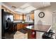 Well-lit kitchen featuring wooden cabinets, black appliances, and a skylight at 10030 W Indian School Rd # 203, Phoenix, AZ 85037