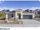 Charming single-story home featuring a two-car garage and a desert landscape against a backdrop of mountains at 10035 S 23Rd Dr, Phoenix, AZ 85041