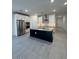 Open concept kitchen with stainless steel appliances, a gray backsplash, and an island at 10035 S 23Rd Dr, Phoenix, AZ 85041