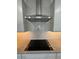 Gourmet kitchen featuring a stainless steel range hood, an electric cooktop and a gray backsplash at 10035 S 23Rd Dr, Phoenix, AZ 85041