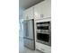 Modern kitchen with stainless steel appliances, double wall ovens, and white cabinetry at 10035 S 23Rd Dr, Phoenix, AZ 85041