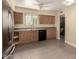 Kitchen featuring wooden cabinets, black appliances, and neutral countertops at 10713 N 36Th Ave, Phoenix, AZ 85029