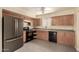 View of the kitchen featuring wood cabinets, stainless refrigerator and black appliances at 10713 N 36Th Ave, Phoenix, AZ 85029