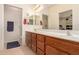 A bathroom featuring a double sink vanity with wood cabinets, a toilet, and a shower at 10960 E Monte Ave # 131, Mesa, AZ 85209