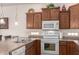 Well-lit kitchen with wood cabinets, breakfast bar, and white appliances at 10960 E Monte Ave # 131, Mesa, AZ 85209