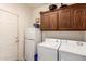 A well-lit laundry room features a washer, dryer, mini refrigerator, and oak-colored cabinets at 10960 E Monte Ave # 131, Mesa, AZ 85209