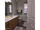 Bright bathroom featuring a double sink vanity, wood-look flooring, and ample natural light from a sheer-curtained window at 11411 N 91St Ave # 175, Peoria, AZ 85345