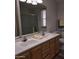 Bathroom showcasing a double sink vanity with white countertop, wood cabinets, and a large mirror at 11411 N 91St Ave # 175, Peoria, AZ 85345