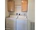 Bright laundry room includes a washer and dryer with cabinets above at 11411 N 91St Ave # 175, Peoria, AZ 85345