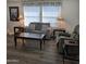 Cozy living room with wood laminate flooring, a comfortable sofa, and a green recliner at 11411 N 91St Ave # 175, Peoria, AZ 85345
