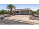 Charming home with a large driveway, a desert landscape, and mature palm trees enhancing curb appeal at 13007 W Butterfield Dr, Sun City West, AZ 85375