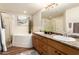 Bathroom featuring double sinks, granite counters, tile accents, and a full shower and soaking tub at 14250 W Wigwam Blvd # 812, Litchfield Park, AZ 85340